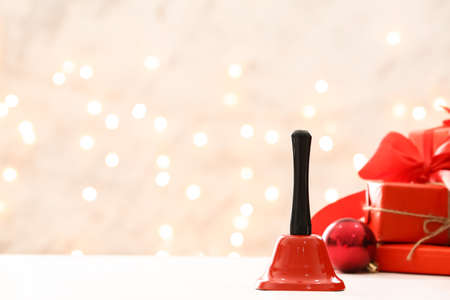 Red Christmas bell on table against blurred backgroundの写真素材