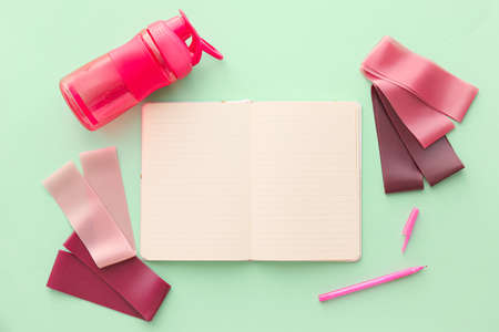 Stylish sport equipment and blank notebook on green backgroundの写真素材