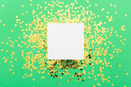 Blank card and beautiful golden confetti on color backgroundの写真素材