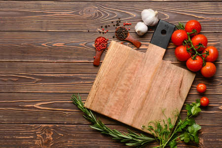 New cutting board with tomatoes and spices on wooden backgroundの写真素材