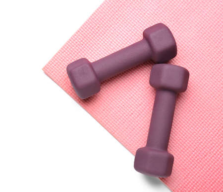 Stylish dumbbells and fitness mat on white backgroundの写真素材