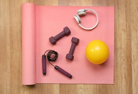 Stylish sport equipment and headphones on wooden backgroundの写真素材