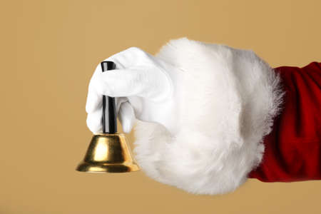 Santa Claus holding Christmas bell on color background, closeupの写真素材