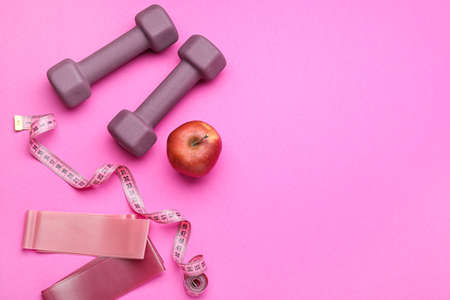 Stylish sport equipment and apple on pink backgroundの写真素材