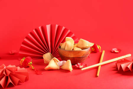 Bowl with tasty fortune cookies and Chinese symbols on color backgroundの写真素材