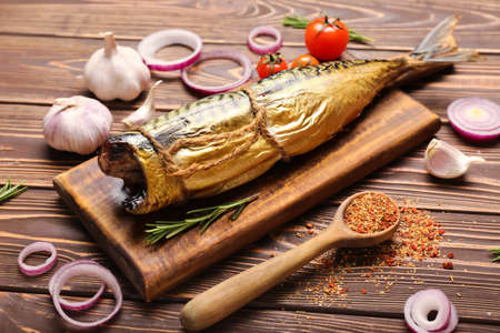 Board with tasty smoked mackerel on tableの写真素材