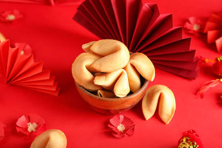 Bowl with tasty fortune cookies and Chinese symbols on color backgroundの写真素材