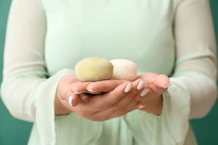 Asian woman with tasty Japanese mochi on color background, closeupの写真素材