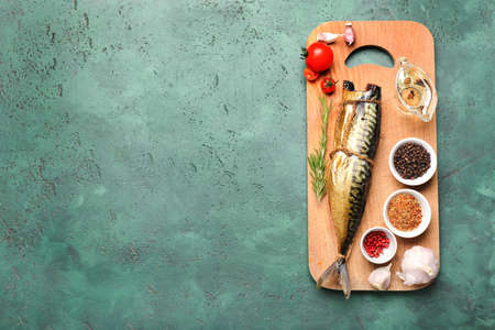 Board with tasty smoked mackerel and spices on color backgroundの写真素材