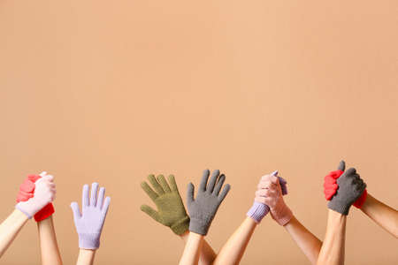 Women in warm gloves on beige backgroundの写真素材
