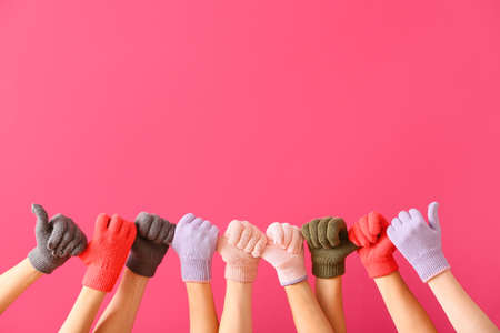 Women in warm gloves on color backgroundの写真素材