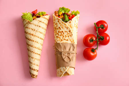 Delicious burritos and tomatoes on pink backgroundの写真素材