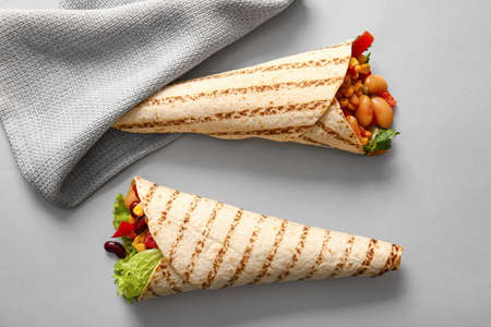 Delicious burritos on gray background