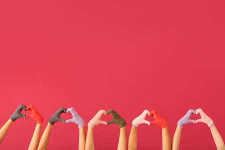 Women in warm gloves on color backgroundの写真素材