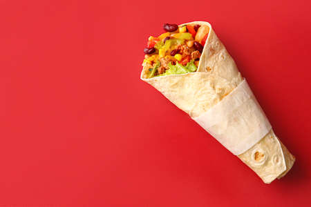 Delicious burrito on red background
