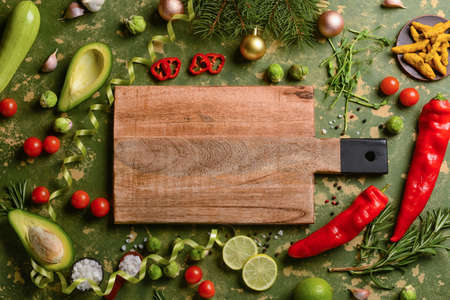 Wooden cutting board with tasty food and spices on grunge background