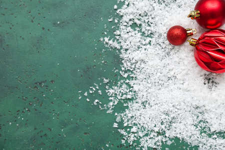 Red Christmas decorations and snow on green backgroundの写真素材
