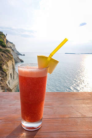 Glass of fresh tropical cocktail on table at sea resortの写真素材