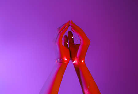 Woman with glowing lights on purple backgroundの写真素材