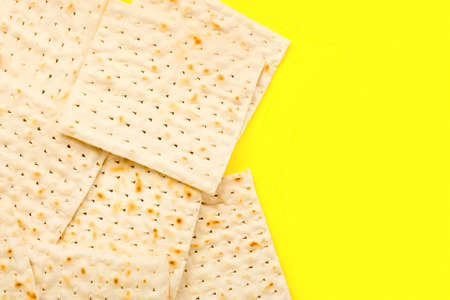 Jewish flatbread matza for Passover on yellow background
