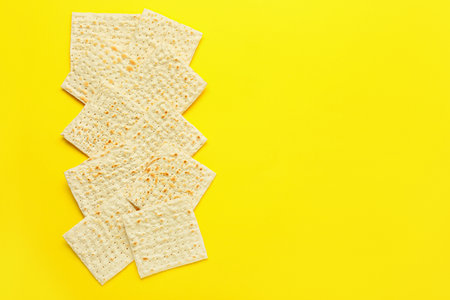 Jewish flatbread matza for Passover on yellow background