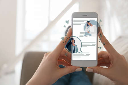 Young woman with mobile phone chatting online at home