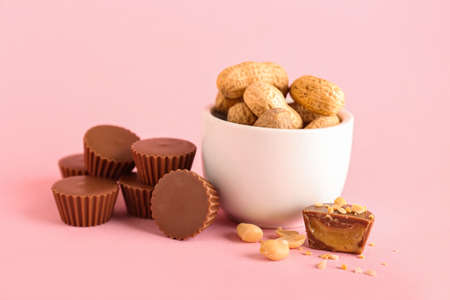Tasty peanut butter cups on color backgroundの写真素材