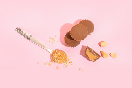 Tasty peanut butter cups on color backgroundの写真素材