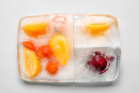 Fresh vegetables frozen in ice on light backgroundの写真素材