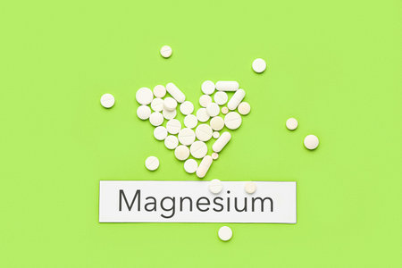 Heart made of pills and word Magnesium on green backgroundの写真素材