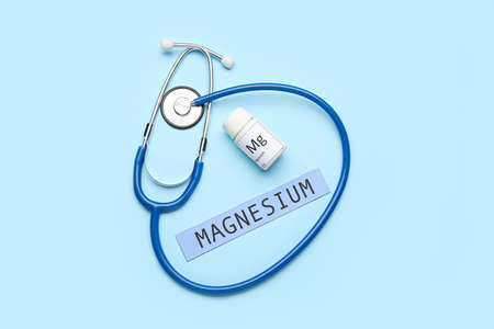 Bottle of pills, word MAGNESIUM and stethoscope on color backgroundの写真素材