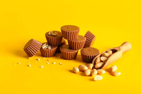 Tasty peanut butter cups on color backgroundの写真素材