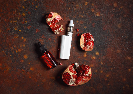 Modern vape mod and pomegranate on color backgroundの写真素材