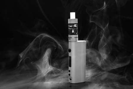 Modern vape mod and smoke on black background