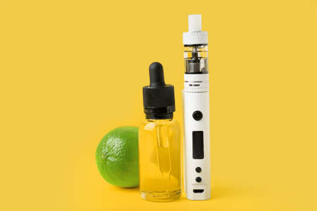 Modern vape mod, oil and lime on yellow backgroundの写真素材