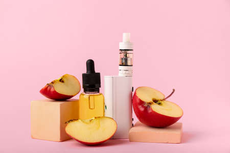 Modern vape mod, oil and apple on pink backgroundの写真素材