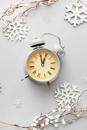 Stylish alarm clock and Christmas decor on light backgroundの写真素材
