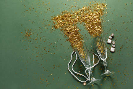 Composition with champagne glasses, golden confetti and female accessories on color backgroundの写真素材