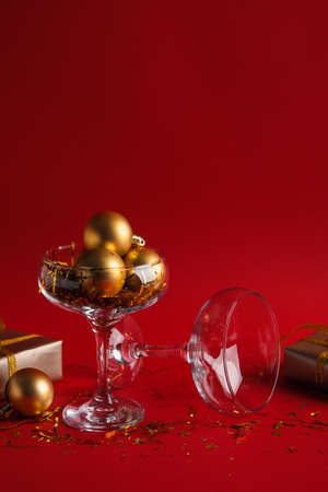 Glass with Christmas decorations on red backgroundの写真素材