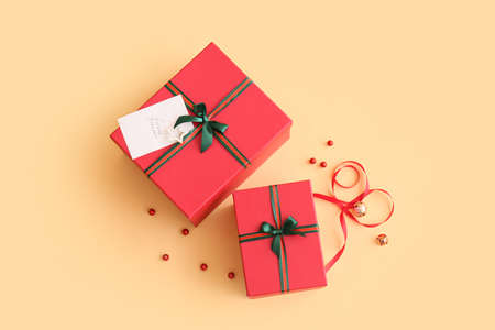 Beautiful Christmas gift boxes with greeting card on beige background