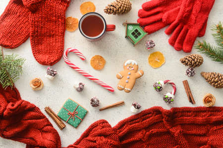 Composition with Christmas clothes, sweets and cup of tea on light backgroundの写真素材