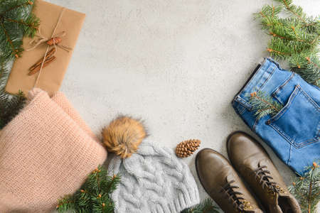 Set of Christmas clothes, shoes and fir branches on light backgroundの写真素材