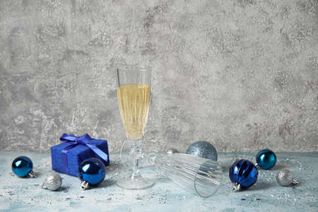 Glass of champagne, Christmas balls and gift on grunge backgroundの写真素材