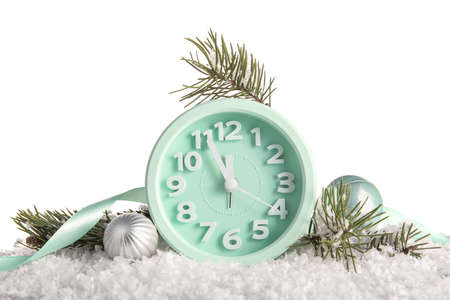 Christmas composition with alarm clock, decorations and snow on white background