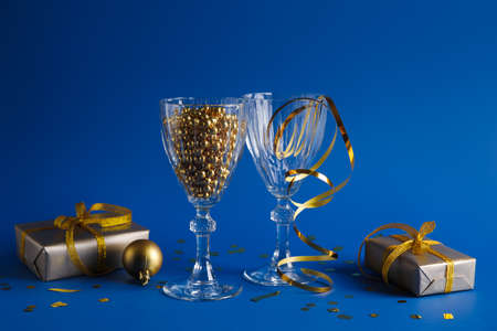 Glasses with Christmas decorations and gifts on blue backgroundの写真素材