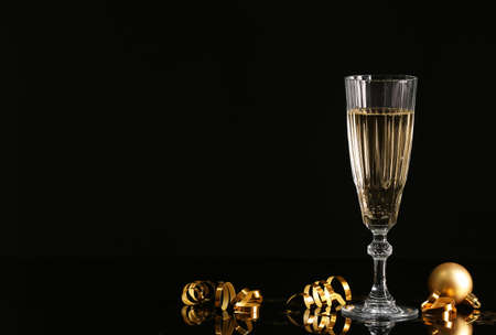 Glass of champagne and serpentine on dark backgroundの写真素材