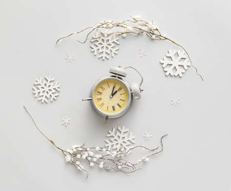 Stylish alarm clock and Christmas decor on light backgroundの写真素材