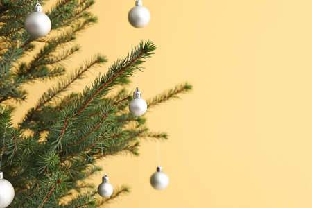 Beautiful decorated Christmas tree near yellow wall, closeupの写真素材