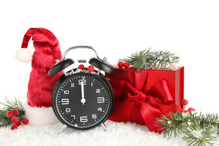 Beautiful composition with alarm clock, Christmas gift and snow on white background