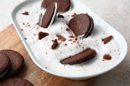 Bowl with tasty chocolate cookies and cream on table, closeupの写真素材